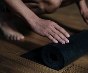 Textured black yoga mat rolled out on a floor